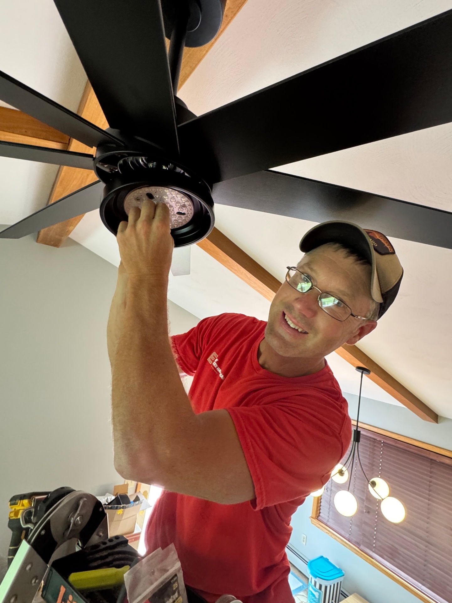 Professional handyman installing a ceiling light fixture inside an Erie County home